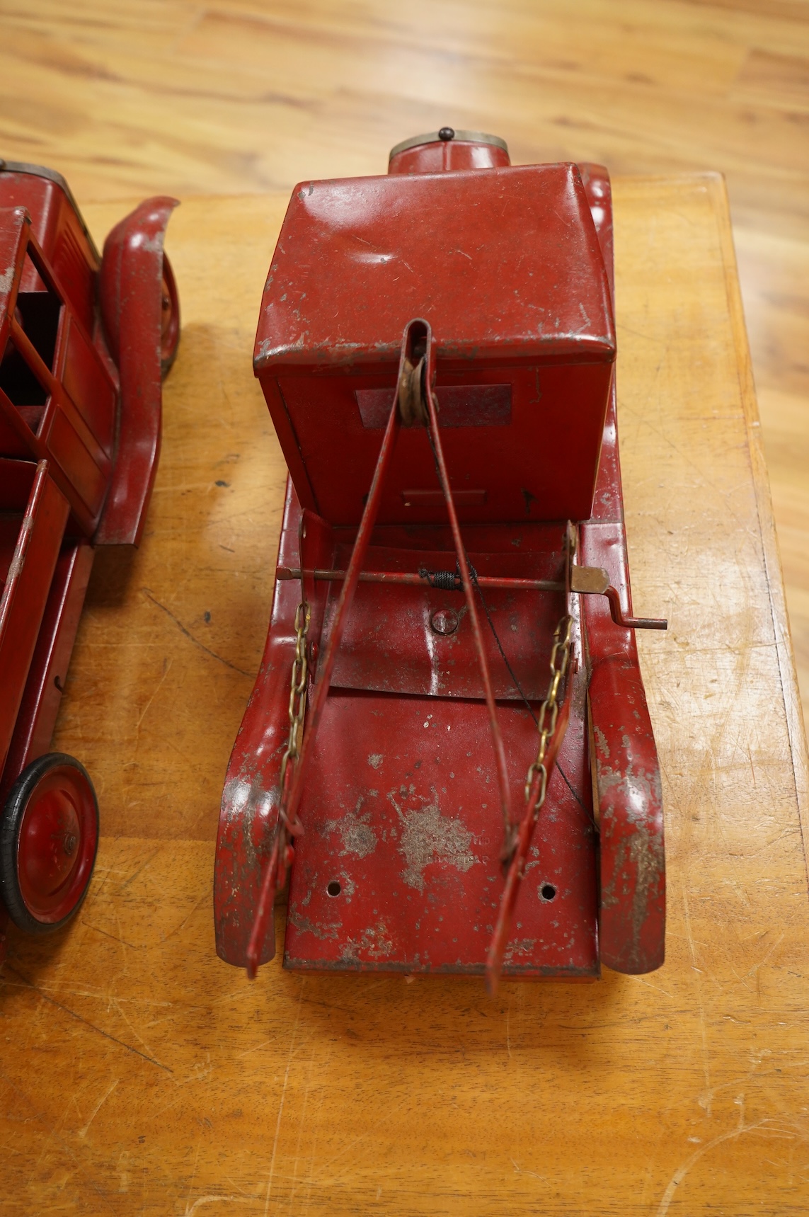 Two 1930's/40's Tri-ang large scale tinplate trucks, both with similar frames and cabs, one as a wreck truck with mounted crane, the other has a wagon with painted wooden blocks, each approximate 44cm long